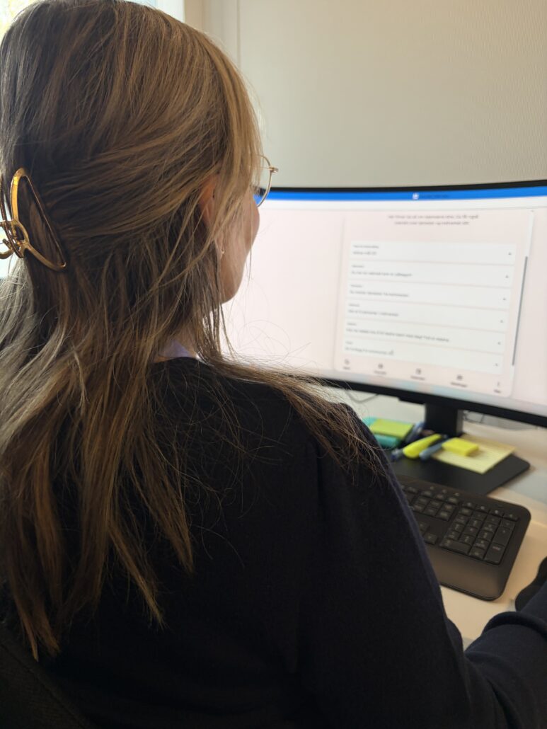 Person foran pc skjerm med Aidn på.
